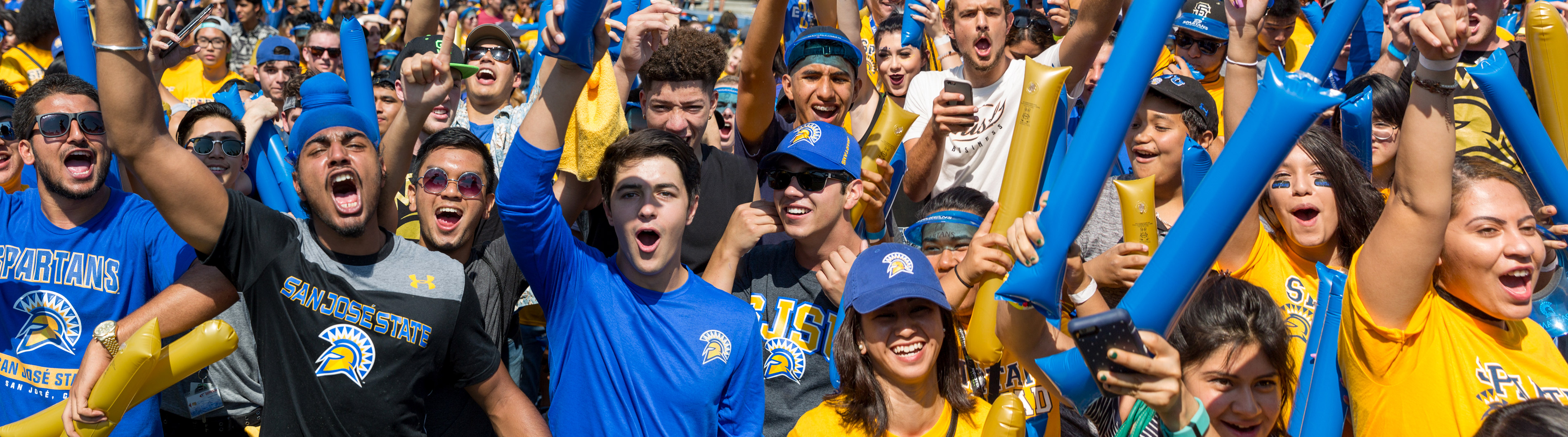 Community members in SJSU gear cheer on during a football game.