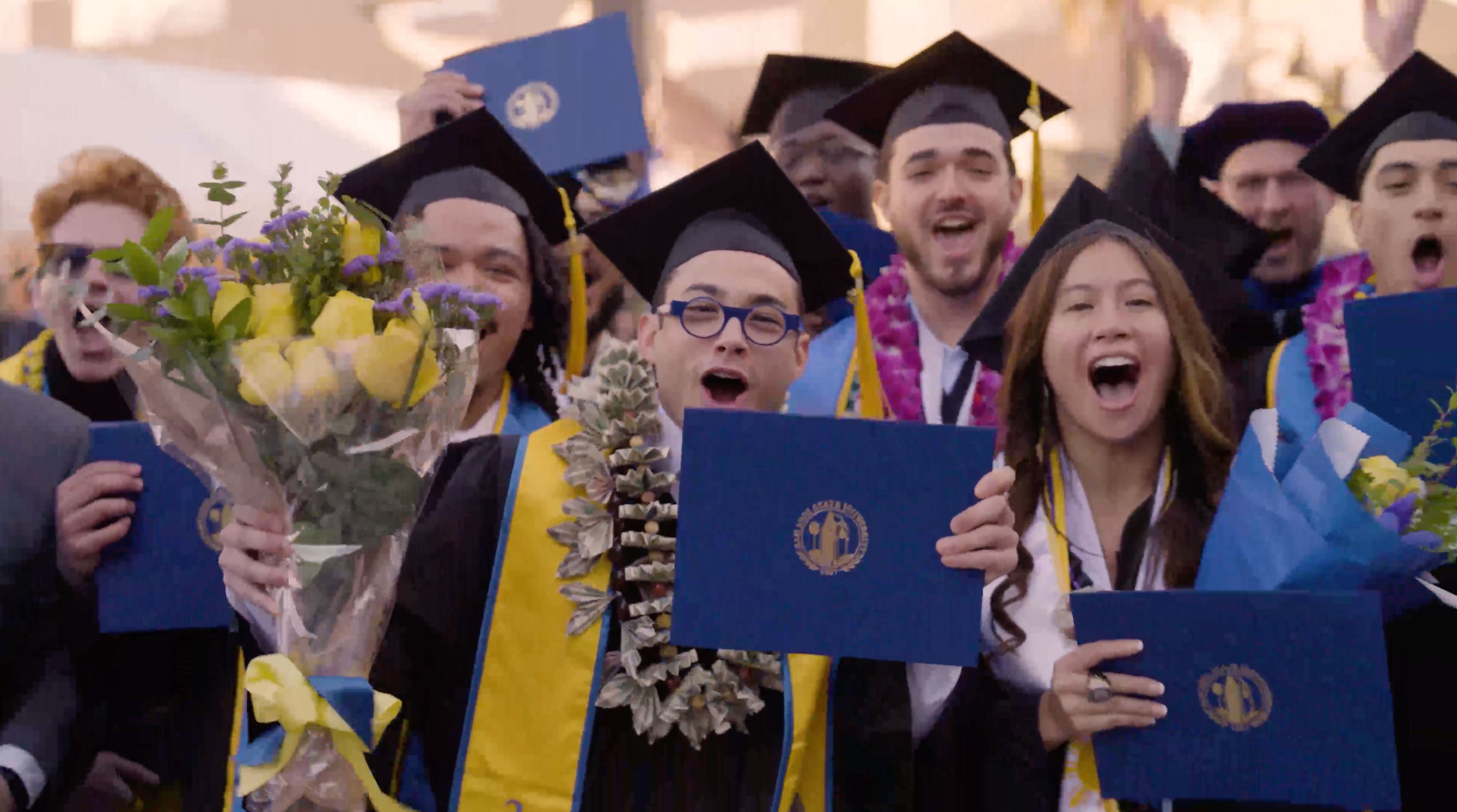 Group photo of graduates cheering