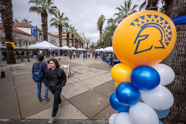 Photo of students walking along the Paseo during a tabling event