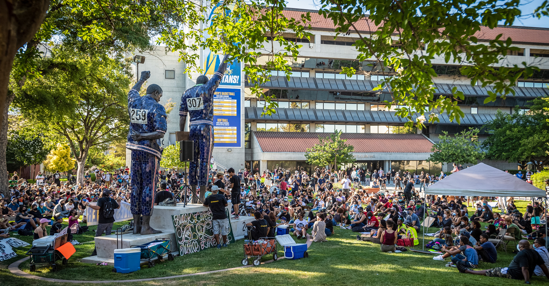 SJSU community members gather in protest in front of the Victory Salute statue.