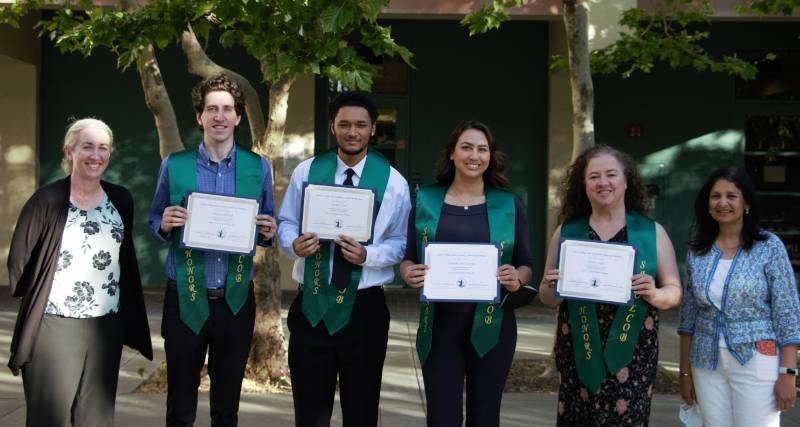 Group of Sbona Grads posing with their stoles and certificates