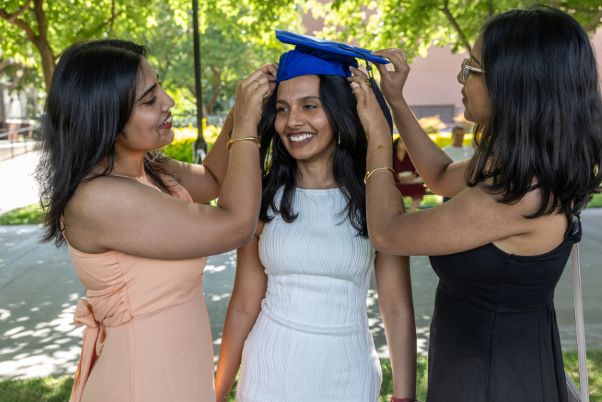 Family members adjusting a graduate's cap