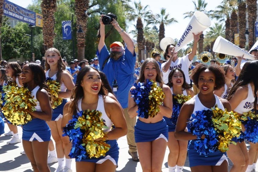 SJSU photographer in the middle of a crowd taking photos.