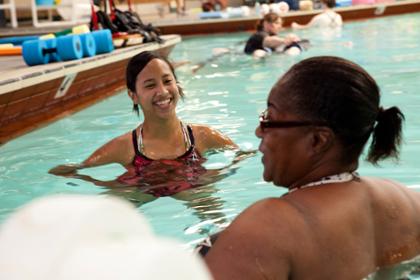 Two women stand in a swimming pool at the Timpany Center.