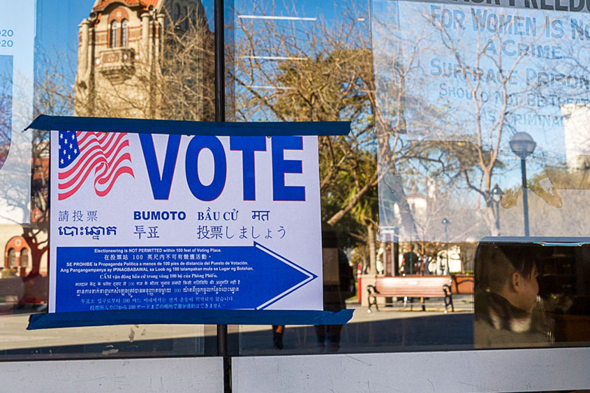 A poster on a building that directs where to vote.