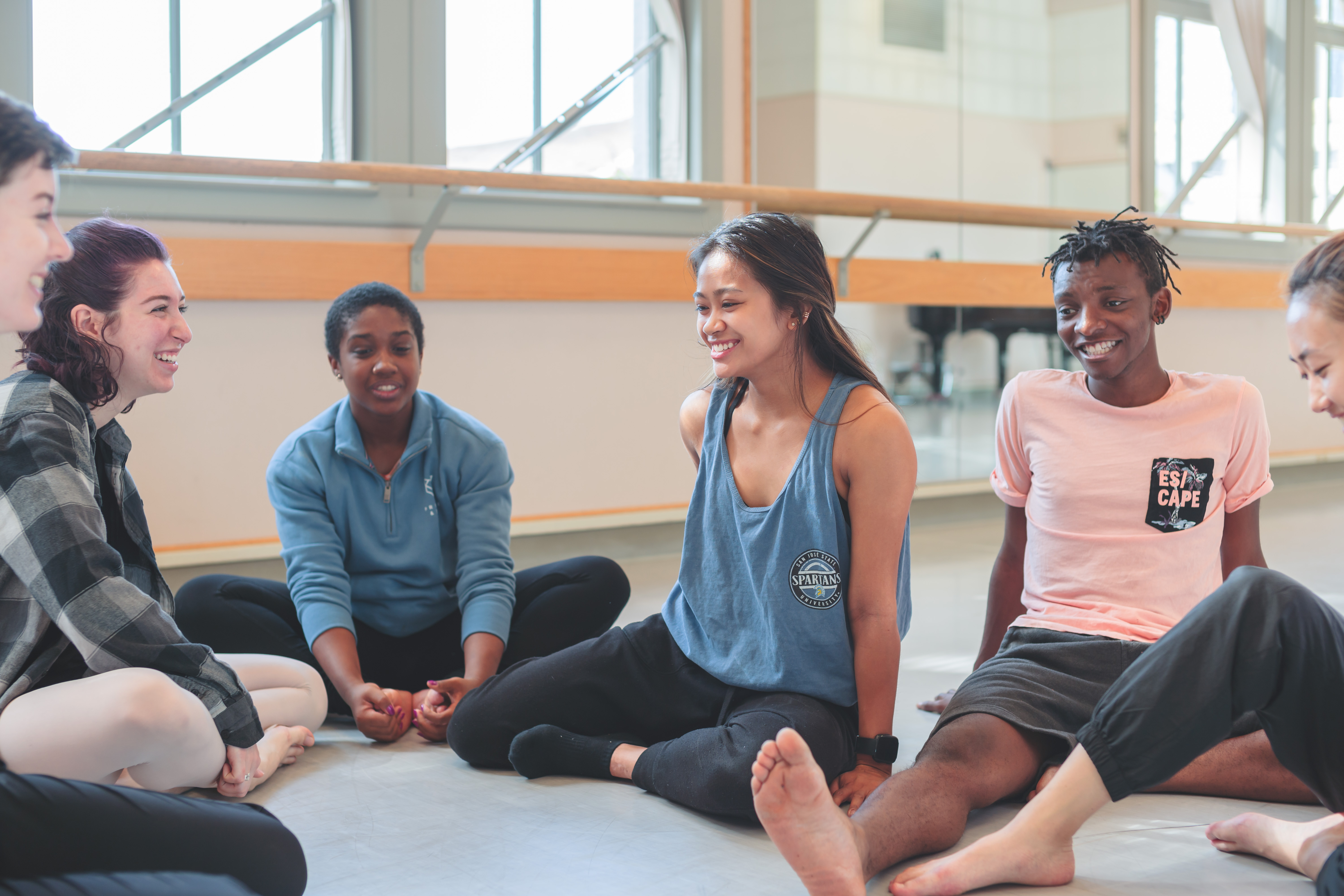 Dancers lounging and talking in a dance stuido