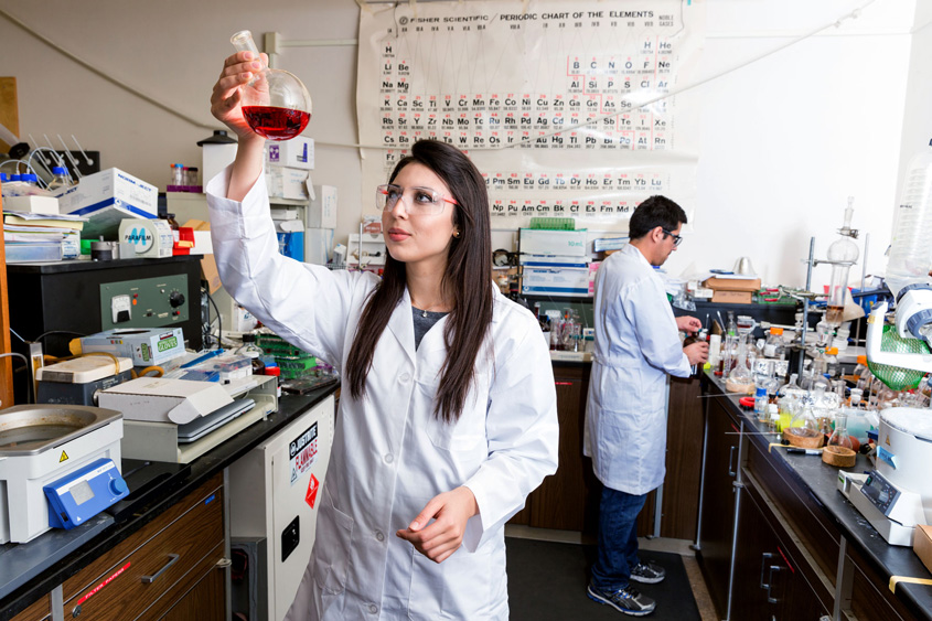 Two students in a science lab conducting work.