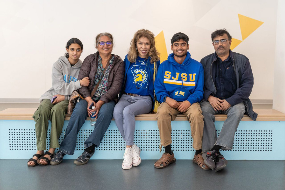 The president posing with a student and their family.