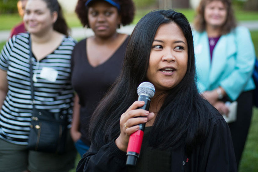 SJSU community member holding a mic and talking.