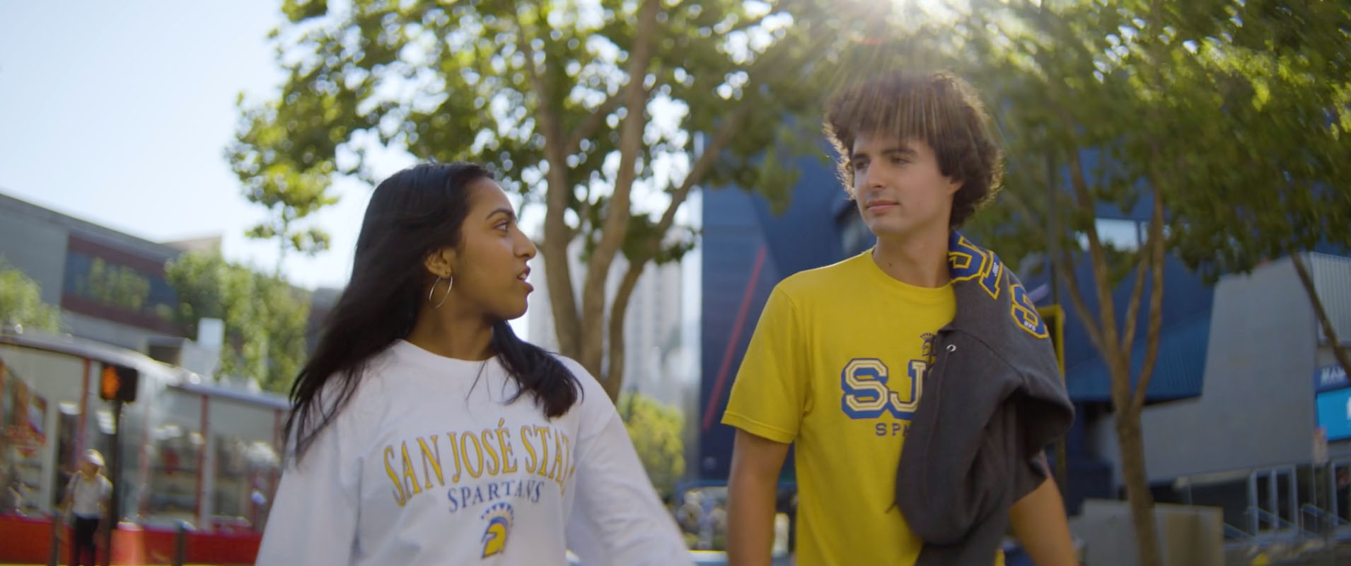 Two SJSU students talking and walking through the Paseo, next to the Hammer Theater. 