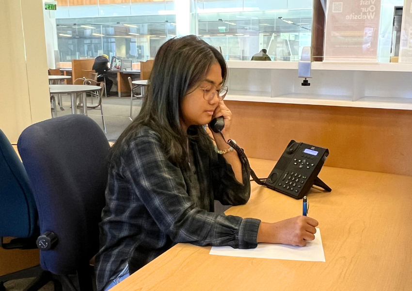 Student assistant sitting at the front-desk answering phone call